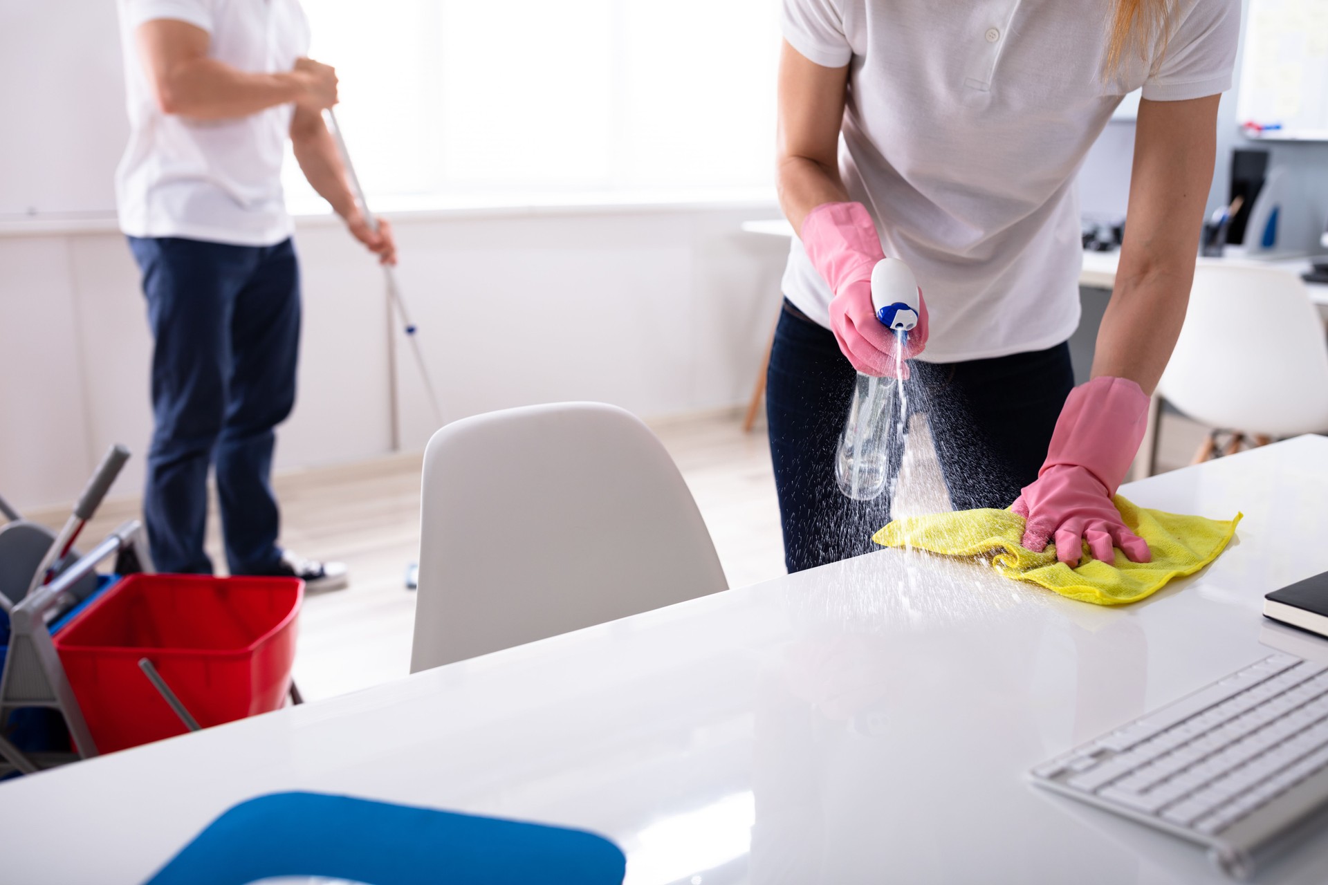Deux jeunes concierges nettoyant le bureau